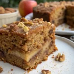 Freshly baked apple spice cake , with chunks of apple peeking through the golden-brown crust.